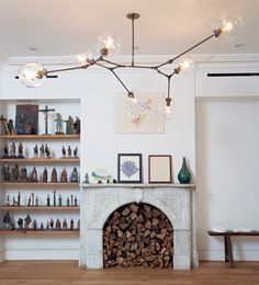 a living room filled with furniture and a fire place under a chandelier over a fireplace