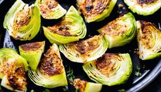 an iron skillet filled with cooked artichokes