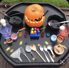 an outdoor table with halloween decorations and utensils