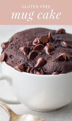 a close up of a chocolate mug cake in a white bowl with a spoon on the side