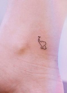 an elephant tattoo on the ankle that is black and white, with a small dot in the middle