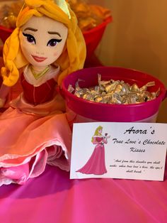 a princess doll sitting next to a bowl of candy