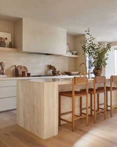 a kitchen with an island and wooden chairs