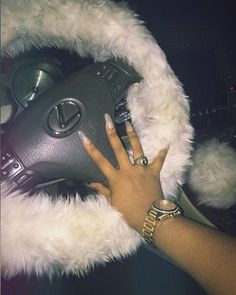 a woman is holding her hand on the steering wheel