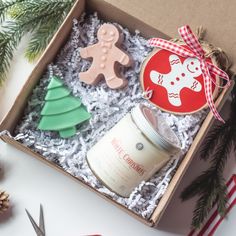 an open box with some cookies and other items in it next to christmas tree decorations