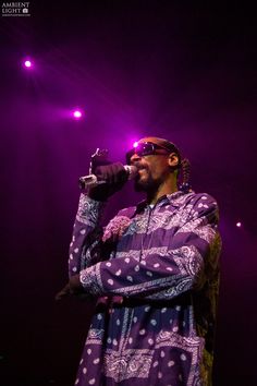 a man standing on top of a stage holding a microphone in his hand and singing