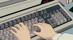 a person typing on an old fashioned computer