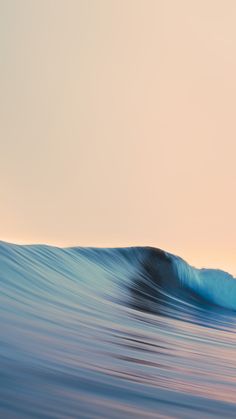 a man riding a wave on top of a surfboard in the ocean at sunset