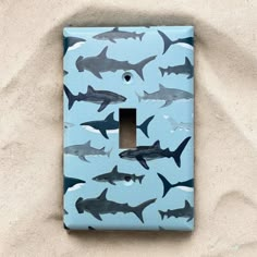 a light switch cover with sharks painted on it