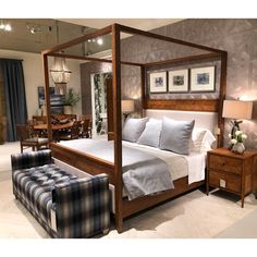 a bedroom with a four poster bed and blue checkered furniture in the foreground