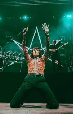 a man with his arms in the air on stage