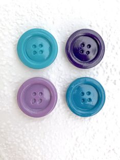 three different colored buttons on a white surface