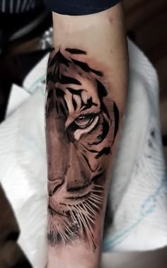 a black and white tiger tattoo on the arm