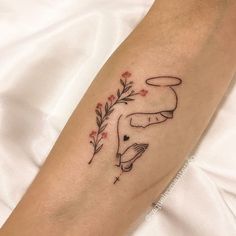 a woman's arm with a tattoo on it and flowers in the middle of her arm