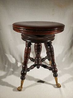 an antique wooden stool with turned legs and foot rests on a white background in the shadow