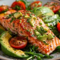 salmon with avocado and tomatoes on a plate