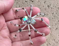 a person is holding a crystal snowflake in their hand