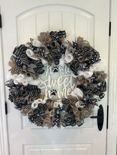 a wreath that says you're sweet home with black and white bows on it