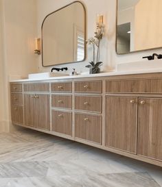 a bathroom with two sinks and mirrors on the wall