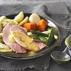 a plate with ham, potatoes, carrots and mashed potatoes