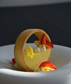 there is a small dessert on the plate with fruit in it and garnishes