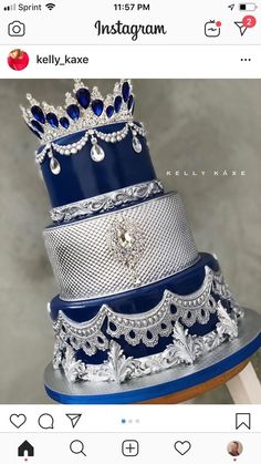 a three tiered cake with blue and silver frosting on the top is adorned with crystal jewels