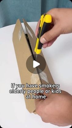 a person cutting out a piece of cardboard with a pair of scissors