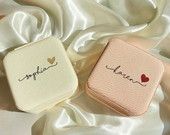 three small personalized coasters sitting on top of a white satin covered bed sheet