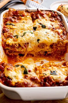 lasagna casserole with meat and cheese in a white dish on a wooden table