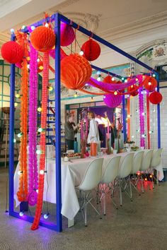 a room with tables, chairs and decorations on the table is decorated in bright colors