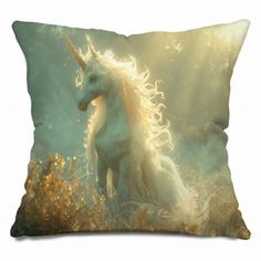 a white unicorn sitting on top of a pillow in the middle of a grass covered field