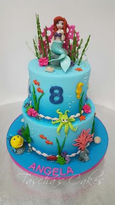 a birthday cake with an image of a mermaid on top and under the seaweed