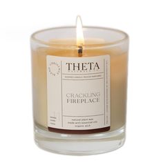 a candle that is sitting in a glass container with the label cracking fireplace on it