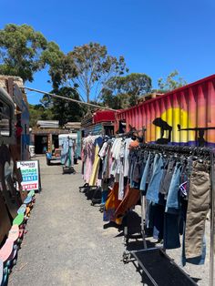 an outdoor clothing market with clothes on racks