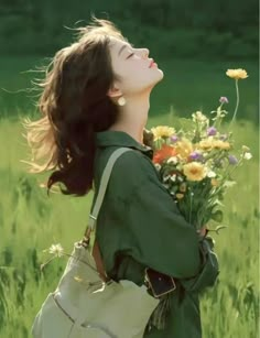 a woman standing in a field with flowers looking up at the sky and holding onto her purse