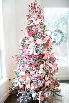 a christmas tree decorated with pink and white ribbons