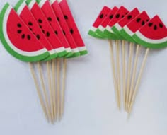 watermelon slices are on sticks with toothpicks in them