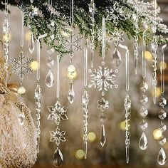 christmas decorations hanging from a tree with snowflakes and baubles on it