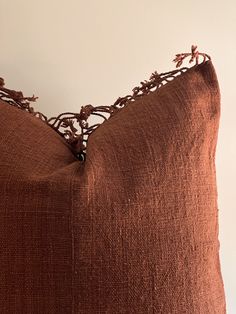 a close up of a brown pillow on a white wall