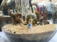 star wars figurines are in a glass bowl on a table with other toys