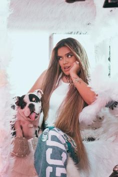 a woman with long hair sitting next to a dog