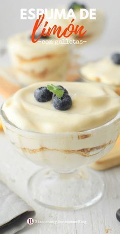 some desserts with blueberries and cream in them on a white tablecloth next to bananas