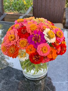 a glass vase filled with colorful flowers on top of a table