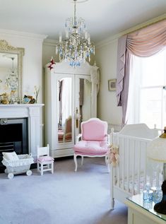 a baby's room with pink furniture and chandelier