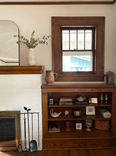 a living room with a fire place and a mirror