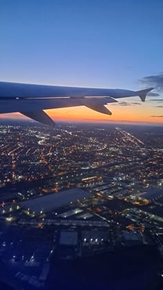 an airplane wing flying over a city at night