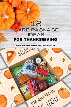 an open box filled with treats and candy sitting on top of a table next to pumpkins