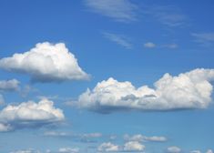 the sky is filled with white clouds and green grass in front of a blue sky