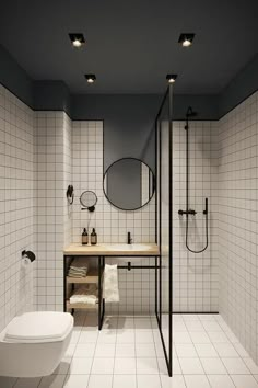 a bathroom with black and white tiles on the walls, a sink, mirror, toilet and shower stall