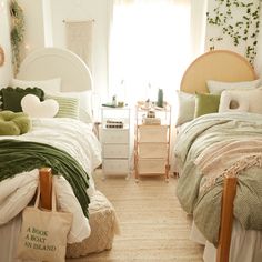 two twin beds in a bedroom with green and white bedding, pillows and blankets